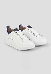 Sneakers bianchi in pelle con superficie testurizzata, dettagli in blu navy sul colletto, lacci piatti e suola in gomma bianca. Logo sul lato.