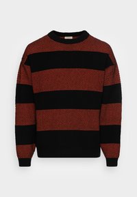 Jersey a rayas negro y naranja con cuello redondo, patrón de tejido texturizado y puños y dobladillo acanalados. Las rayas alternan en ancho.