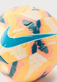 Bola de futebol da Nike com superfície texturizada amarela, apresentando padrões abstratos azuis e rosa e um logótipo azul proeminente.