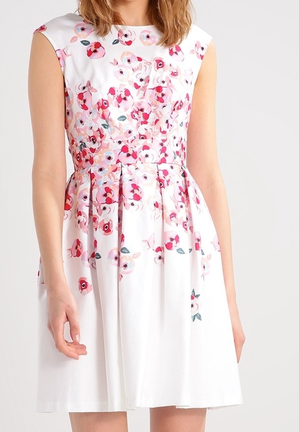 Robe blanche avec un corsage ajusté et une jupe évasée, présentant un motif floral aux nuances de rose et de vert. Tissu lisse, design sans manches.