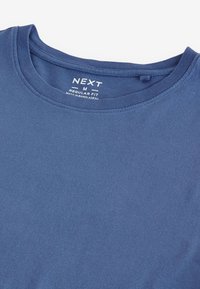 Tengerészkék pamut póló kerek nyakkivágással, normál szabással. Sima textúrával és címkemárkával a nyakkivágásnál.