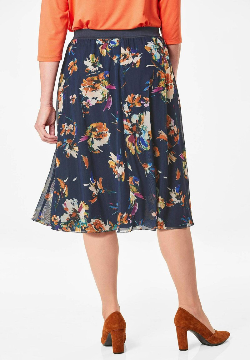 Florale midi-rok in marineblauw met oranje, crèmekleurige en groene bloemen. Heerlijke, lichte stof met een aansluitende tailleband. Versterkt door zij-splitten.
