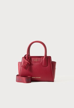 Rode Armani Exchange handtas met dubbele handvatten, gestructureerd oppervlak en afneembare merkriem op een effen achtergrond.