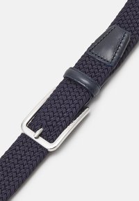 Ceinture en tissu tissé bleu marine avec un accent en cuir lisse et une boucle en argent, ornée de coutures détaillées et d'un design texturé.