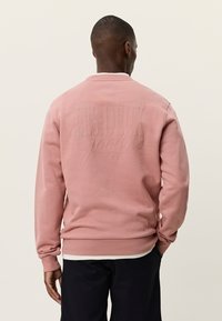 Ροζ φούτερ με ανάγλυφο λογότυπο στην πλάτη, στρογγυλή λαιμόκοψη και ριμπ μανσέτες και τελείωμα. Κανονική εφαρμογή με απαλό υλικό.