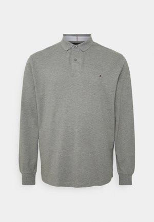 Pitkähihainen harmaa puuvillainen poolopaita. Siinä on kaulus, napillinen etulista ja pieni logo rinnassa. Teksturoitu kangaspinta.