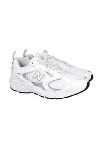 Zapatillas deportivas blancas con parte superior de malla y sintético, que presentan un destacado logo plateado "N", lengüeta acolchada y suela de goma negra texturizada.