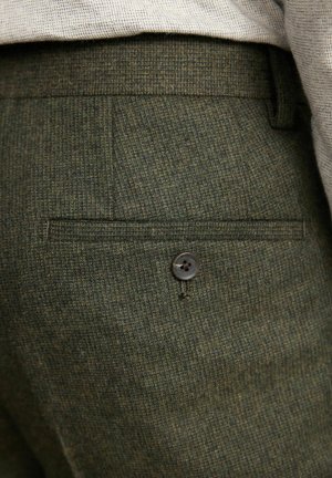 Zielone teksturowane spodnie z tylną kieszenią z pojedynczym ciemnym guzikiem oraz subtelnie wzorowanym materiałem. Dopasowany fason dla wygody.