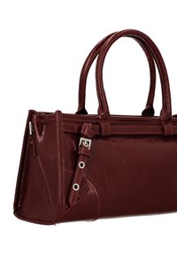 Borsa a mano marrone scuro in similpelle con manici corti, chiusura con zip, cuciture visibili e dettaglio con fibbia laterale. Texture liscia e forma strutturata.