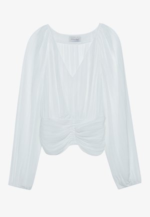 Hvit langermet bluse med V-hals, rynket tekstur, rynkete detaljer i midjen og elastiske mansjetter. Merkenavn er synlig på innsiden.