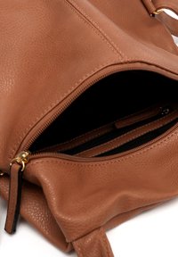 Brown faux leather handbag with a zippered opening, soft texture, interior zip pocket, and gold-tone hardware accents.
