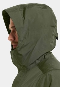 Olijfgroene waterdichte jas met een aansluitende capuchon, gestructureerde stof en zijritsen, met gladde naden en minimalistische ontwerpelementen.