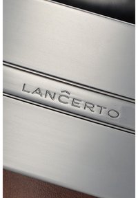Metalowa prostokątna blacha z wygrawerowanym napisem "LANCERTO". Posiada szczotkowaną teksturę, gładkie krawędzie i subtelny połysk na brązowym tle.