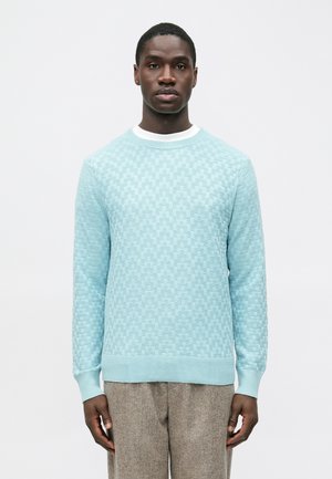Pull tricot bleu clair avec un motif en damier texturé, col rond avec accents blancs, et manches longues.