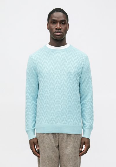 Pull tricot bleu clair avec un motif en damier texturé, col rond avec accents blancs, et manches longues.