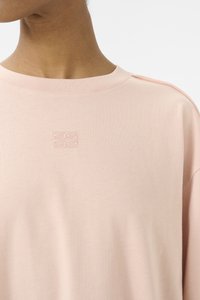 Lys rosa bomullssweatshirt med rund hals, subtilt brodert logo på brystet og avslappet passform med skuldersømmer.