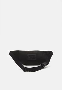 Svart midjeveske laget av glatt, slitesterk stoff. Har justerbar stropp og en flat, rektangulær lomme. Minimalistisk design med en strømlinjeformet finish.