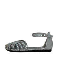 Scarpe piatte metalliche argento con cinturino alla caviglia, design open-toe, ritagli decorativi e dettagli in strass sulla parte superiore.