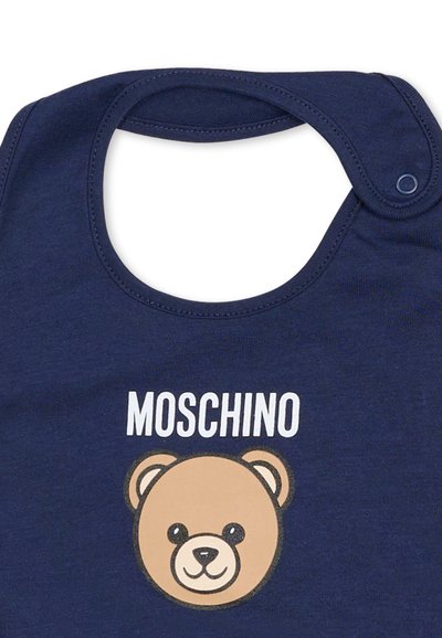 Bavetta in cotone blu navy con chiusura a scatto, con un disegno di una faccia di orso cartoon in beige e nero, e la parola "MOSCHINO" sopra.