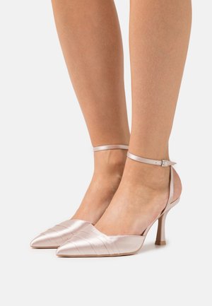Chaussures à talons hauts en satin rose avec bouts pointus, munies d'une fine bride autour de la cheville et de fines rayures verticales sur la tige.