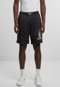 Pantaloni da basket in mesh neri con una comoda vita elastica, dotati di testo grafico bianco e un'etichetta verde.