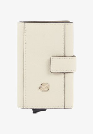 Cartera compacta de cuero crema con bordes cosidos, cierre de broche y un pequeño logo metálico en el centro frontal.