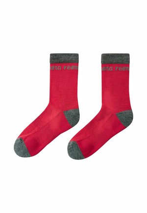 Pair of red socks with gray toes, heels, and cuffs, featuring a partial gray logo near the top on a white background.