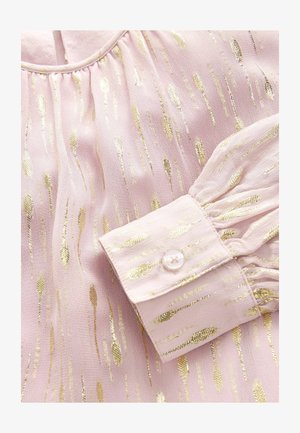 Bluse in blassrosa mit metallischen goldenen Streifenmustern; verfügt über einen gerafften Ausschnitt und Rüschensaum mit Knopfverschluss.