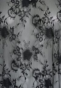 Czarna koronkowa tkanina z kwiatowymi wzorami, złożonymi detalami i siateczkową strukturą, nadająca delikatny i elegancki wygląd.