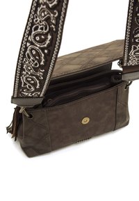 Braune Lederhandtasche mit einem gesteppten Muster, einem dekorativen Tragegurt mit weißen Paisley-Designs und einem magnetischen Druckverschluss.