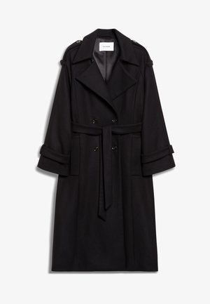 Trench coat de lã preta com frente de dupla abotoadura, cintura cingida por cinto e punhos dobrados. Detalhes notáveis incluem epauletes nos ombros.