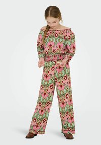 Barevný top bez ramínek s květinovým vzorem, se zmraženým pasem a širokými nohavicemi v odstínech růžové, zelené a hnědé.