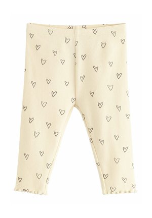 Yellow ribbed leggings featuring a heart pattern in black. Elastic waistband and ruffled hems at the ankles. Soft and stretchy material.