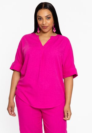 Fuchsia shirt met een V-hals en opgerolde korte mouwen, gemaakt van gestructureerde stof; gecombineerd met bijpassende fuchsia broek.