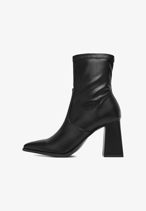 Czarne skórzane botki za kostkę z wydłużonym czubkiem i blokowym obcasem, z przeszywanym wykończeniem u góry oraz gładką, lekko pomarszczoną teksturą.