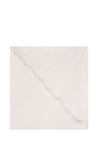 Tissu texturé beige clair et doux, plié en diagonale, présentant un motif subtil en forme de grille et une délicate couture le long du pli.