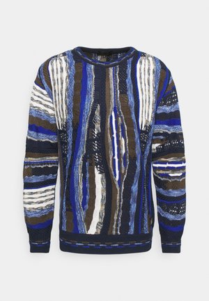 Maglione a maglia con strisce blu, marroni e bianche, caratterizzato da diverse trame e motivi. Collo a giro e polsini e orlo a coste.