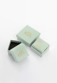 Scatole regalo verde menta con testo in oro embosso, una con coperchio rimovibile, che mostra un interno nero. Design compatto e quadrato.
