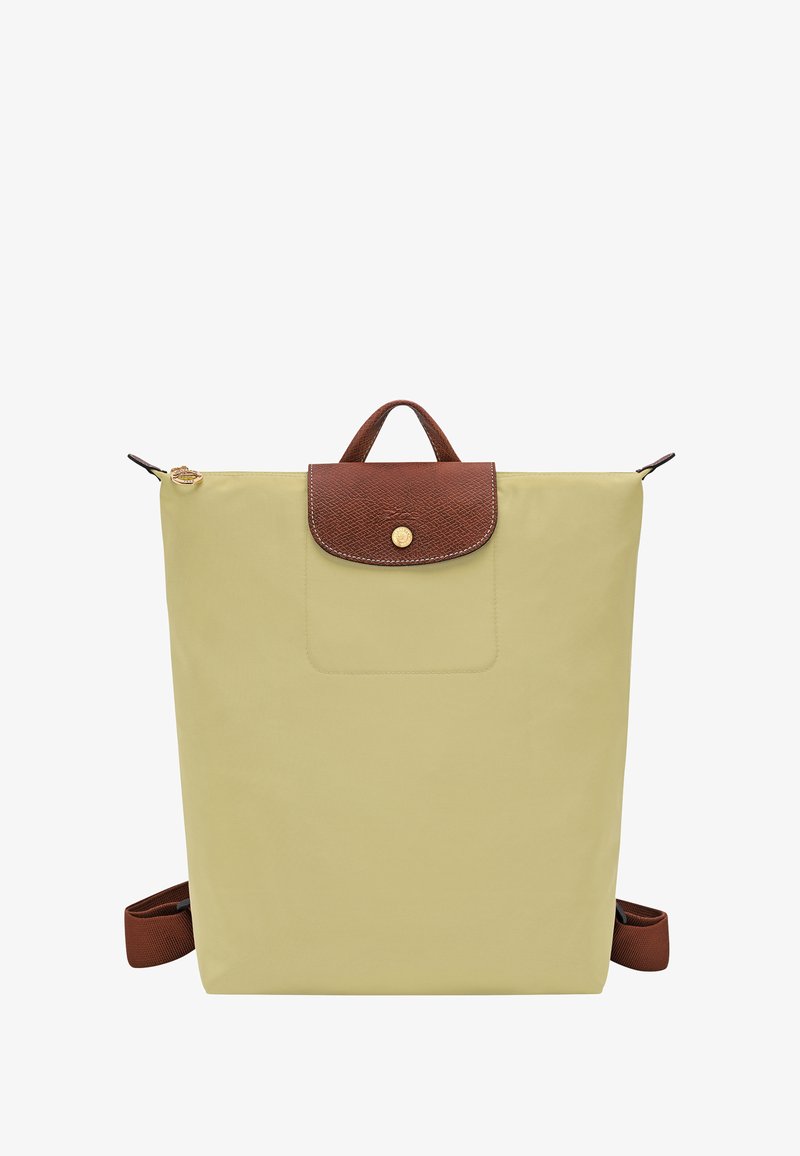 Hellgelber Rucksack mit einer strukturieren braunen oberen Klappe, goldfarbenen Beschlägen, einer Vorderseite-Tasche und verstellbaren braunen Trägern. Kompakte rechteckige Form.