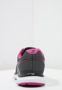 Scarpa da corsa grigia con accenti rosa, tomaia in tessuto testurizzato, controfondale nero e suola bianca con suola rosa.