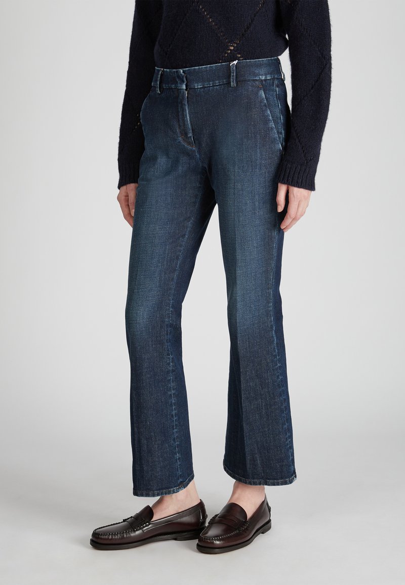 Jeans de mezclilla azul oscuro con un diseño de pierna recta, bolsillos frontales y una cintura de altura media. Textura suave con sutiles detalles de desvanecimiento.