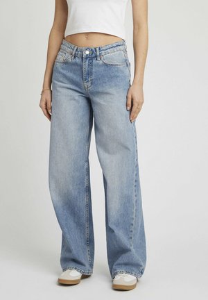Jean large bleu clair en denim, à taille haute, avec un design à cinq poches et une fermeture par bouton, présentant des effets de décoloration subtils.