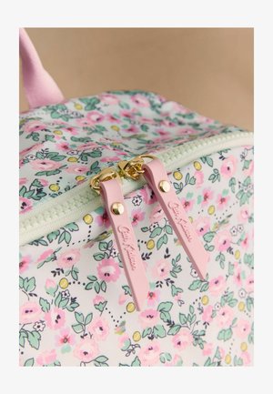 Detailný záber na tašku s kvetinovým vzorom, ružové jazdce na zips a zlaté kovanie na zips, zobrazujúci detailnú textúru látky a dizajn.