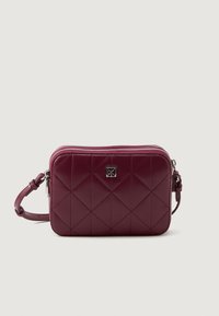 Geantă acoladă de culoare burgundă, fabricată dintr-un material lucios, cu un accent al logo-ului argintiu, închidere cu fermoar și o curea ajustabilă. Design compact, de formă rectangulară.