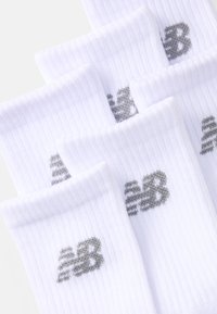 Hvide ribbede sokker med et gråt "NB" logo. Stoffet er blødt og strækbart, med et klassisk crew-længde design velegnet til hverdagsbrug.