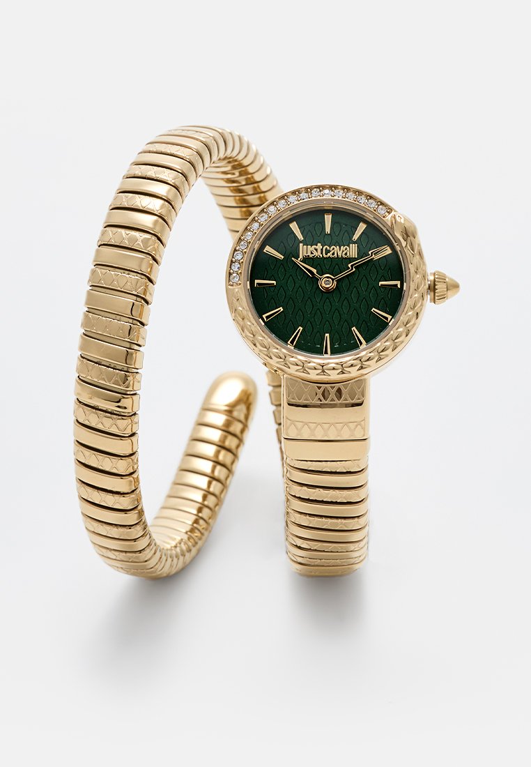 Orologio dorato con un bracciale testurizzato, dotato di un quadrante verde a motivo, accenti in cristallo e una corona laterale per la regolazione.