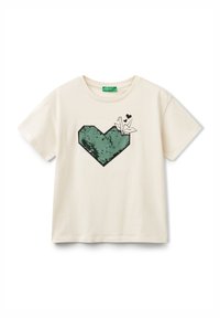 T-shirt crema a maniche corte con grafica di un cuore in paillettes verdi e design in origami nero. Tessuto in cotone morbido con vestibilità comoda.
