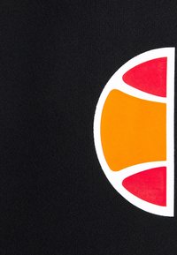 Un tissu noir à la texture lisse présente un grand logo graphique en blanc, orange et rouge, évoquant un design en demi-cercle.