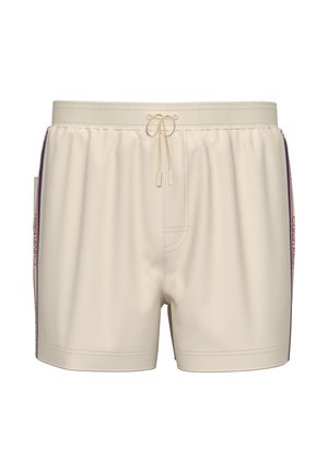 Costume da bagno beige con vita elasticizzata, coulisse frontale, strisce laterali in rosso, bianco e blu, e marchio Calvin Klein lungo i lati.