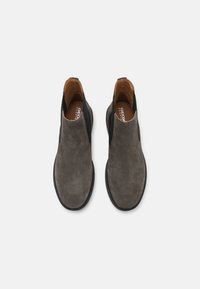 Sive čizme do članaka od suede s elastičnim bočnim detaljima i glatkom crnom potplatom. Unutrašnjost ima smeđu podstavu i detalje s logotipom.